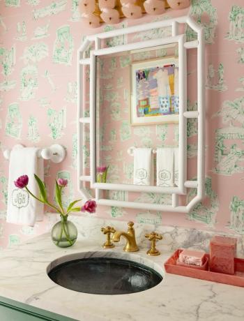 en vask med et speil og en hylle med blomster