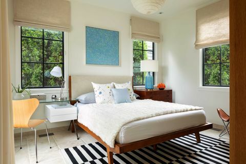 soverom, hvite kremmalte vegger, solbrune gardiner, svart -hvitt strippet teppe, utsikt over utvendige trær