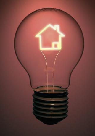 En enkelt huspære inneholder et glødende filament i form av et hus som indikerer energi, strøm og grønne problemer