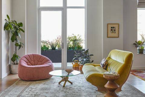 stue med rosa stol og gul sofa