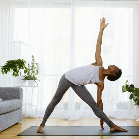 Kvinne som praktiserer yoga hjemme