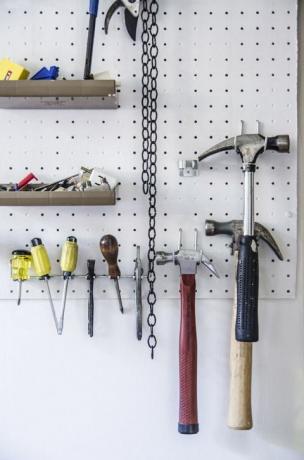 Husholdningsverktøy som henger på tavle på vegg
