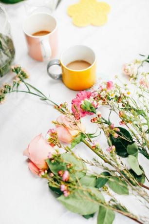 Bord med avskårne blomster og kaffekopper på blomsterarrangørverksted