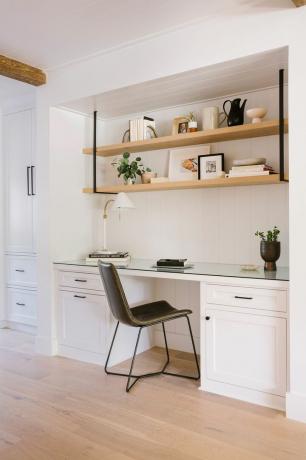 et hvitt kjøkken med en svart stol