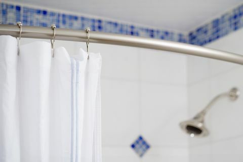Detalje dusjforheng og dusjhode i blå og hvit flislagt dusj
