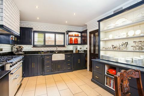 mørkeblått og hvitt kjøkken med butlervask og dobbel komfyr