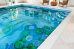 Innendørs svømmebasseng med vakker vannlilje, keramiske fliser, veggmaleri
