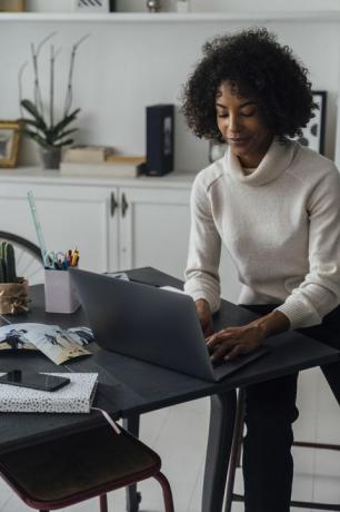 kvinne som arbeider på hjemmekontoret sitt ved hjelp av en laptop