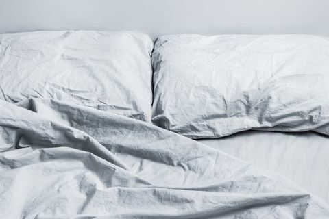 rotete grå sengetøy seng med to puter i dagslys