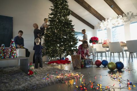 Familie dekorere juletre i stuen