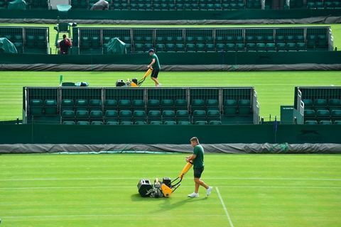 Markpersonalet klipper gresset på en bane ved The All England Lawn Tennis Club i Wimbledon