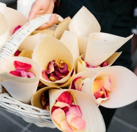 nærbilde av rosenblad i hvite kjegler som sitter i en kurv som skal brukes som konfetti ved en bryllupsseremoni